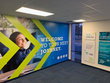 A wall graphic depicts a woman with her arms behind her back and smiling, looking out. The message "Welcome to Your Next Journey," is next to her, superimposed with green arrows. On the other wall are top resume tips for job seekers to consider.