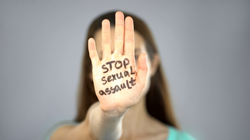 person with hand that has marker written on it with a message to stop sexual assault
