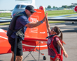 NFL tight end Jimmy Graham, co-chair of the Young Eagles program, gives Madeline Anderson a high-five after their flight. (EAA photo/Connor Madison)
