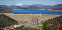 Shasta Dam with the reservoir behind it. Mount Shasta in the background is snowcapped.
