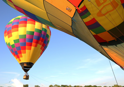 Two hot air balloons fly over Shreveport-Bossier, Louisiana for the Red River Balloon Rally.
