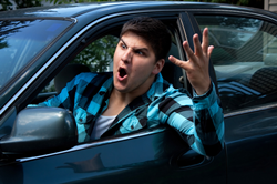 Man with arm out the window he is experiencing road rage