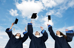 three graduate students tossing their hats in air