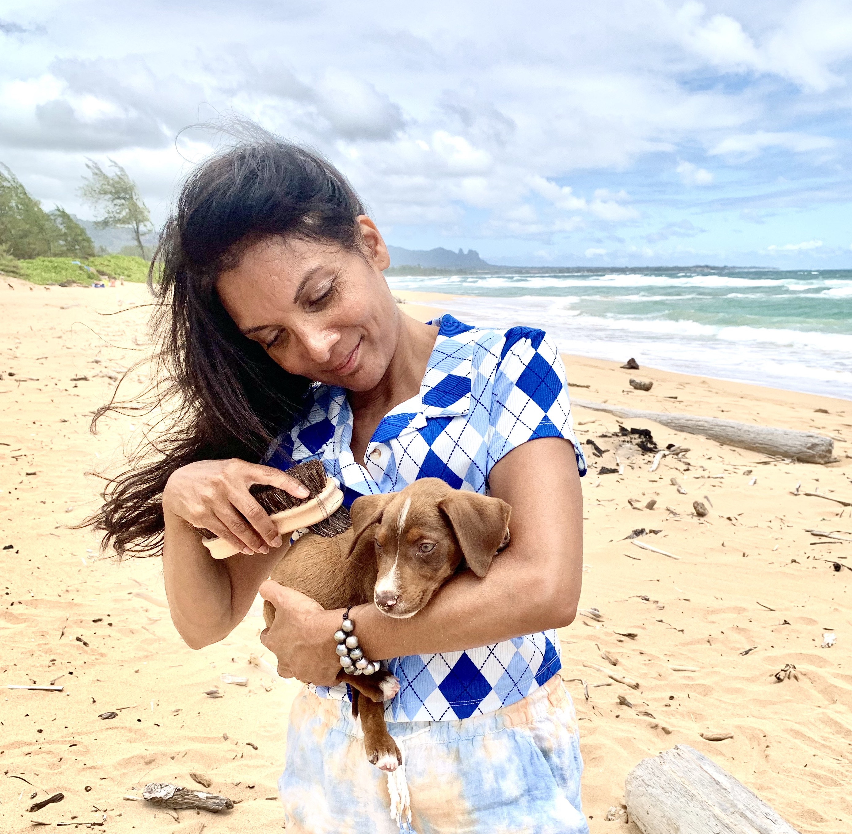 Sujata using sand remover on puppy in Kauai