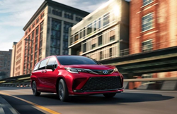 Red 2022 Toyota Sienna cruising on a road