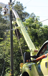A lineworker called out by the ARCOS system handles repairs to an electric distribution line from his bucket truck.