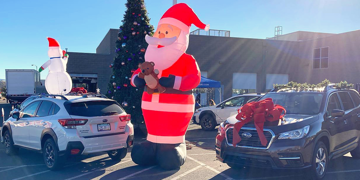 An inflatable Santa stands guard as cars go through Flagstaff Subaru’s Candy Cane Lane event