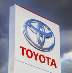 Toyota official dealership sign against a blue sky background