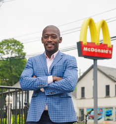 Pod Digital Media CEO Gary Coichy smiles standing outside his first job, a McDonald's in Nyak, N.Y., where he worked as a drive-thru cashier.