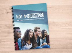 Love146's Not a Number curriculum, a spiral bound booklet on a desk.