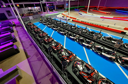 Rows of all-electric indoor go karts sit ready for racers by a large indoor track at K1 Speed Rohnert Park