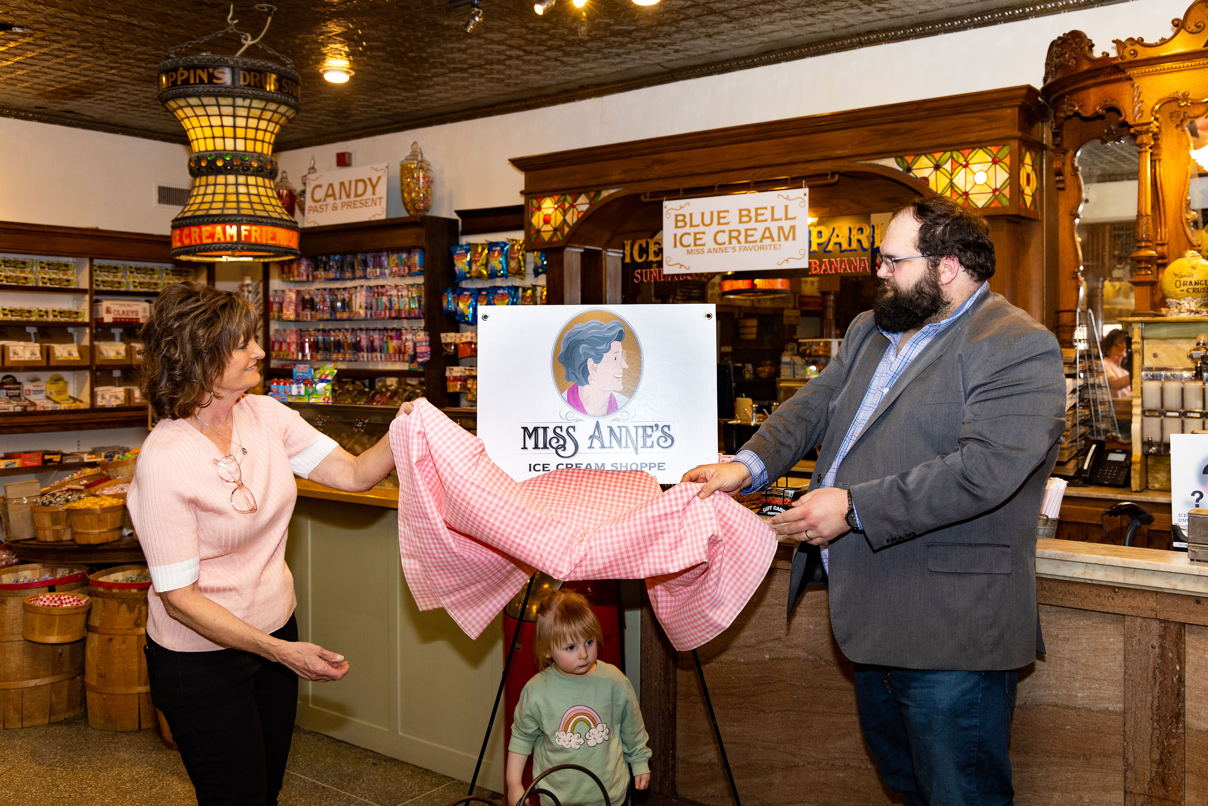 (l to r)OCS Owner Juanita Shaw, Grace Anne Shaw and OCS General Manager Brooks Shaw unveil the new logo for Miss Anne's Ice Cream Shoppe-old-fashioned candy, ice cream and toys-Tuesday, Feb. 15, 2022.