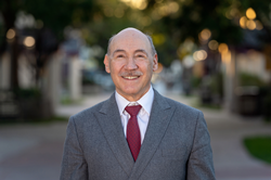 Man in a suit standing on the Esplanade of Western University of Health Sciences in Pomona, California