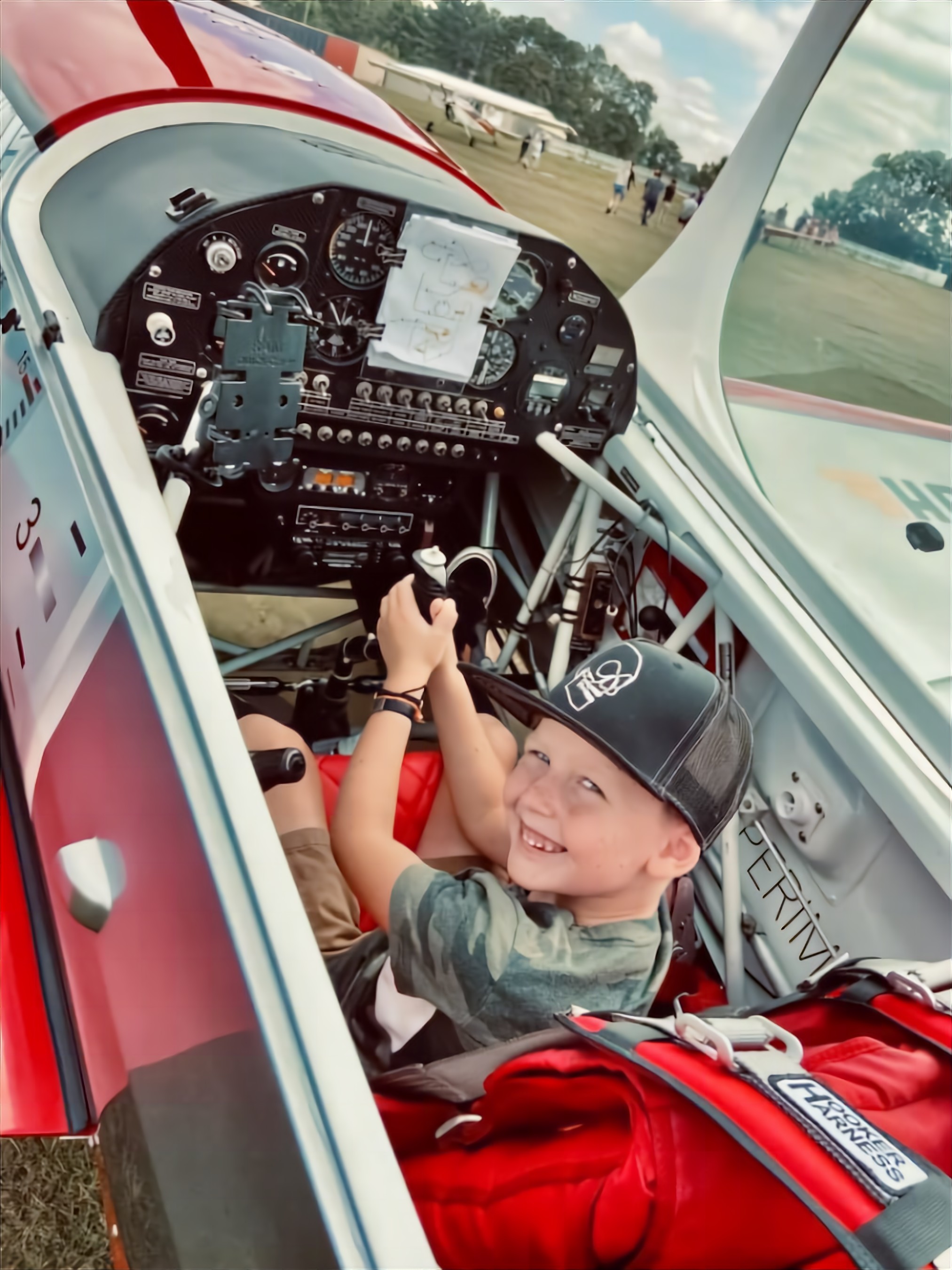 A future pilot -- and perhaps, a future aerobatic competitor -- gets an up-close look at an aerobatic aircraft cockpit during a 2021 aerobatics day event in Willaimson, Georgia. (IAC photo)