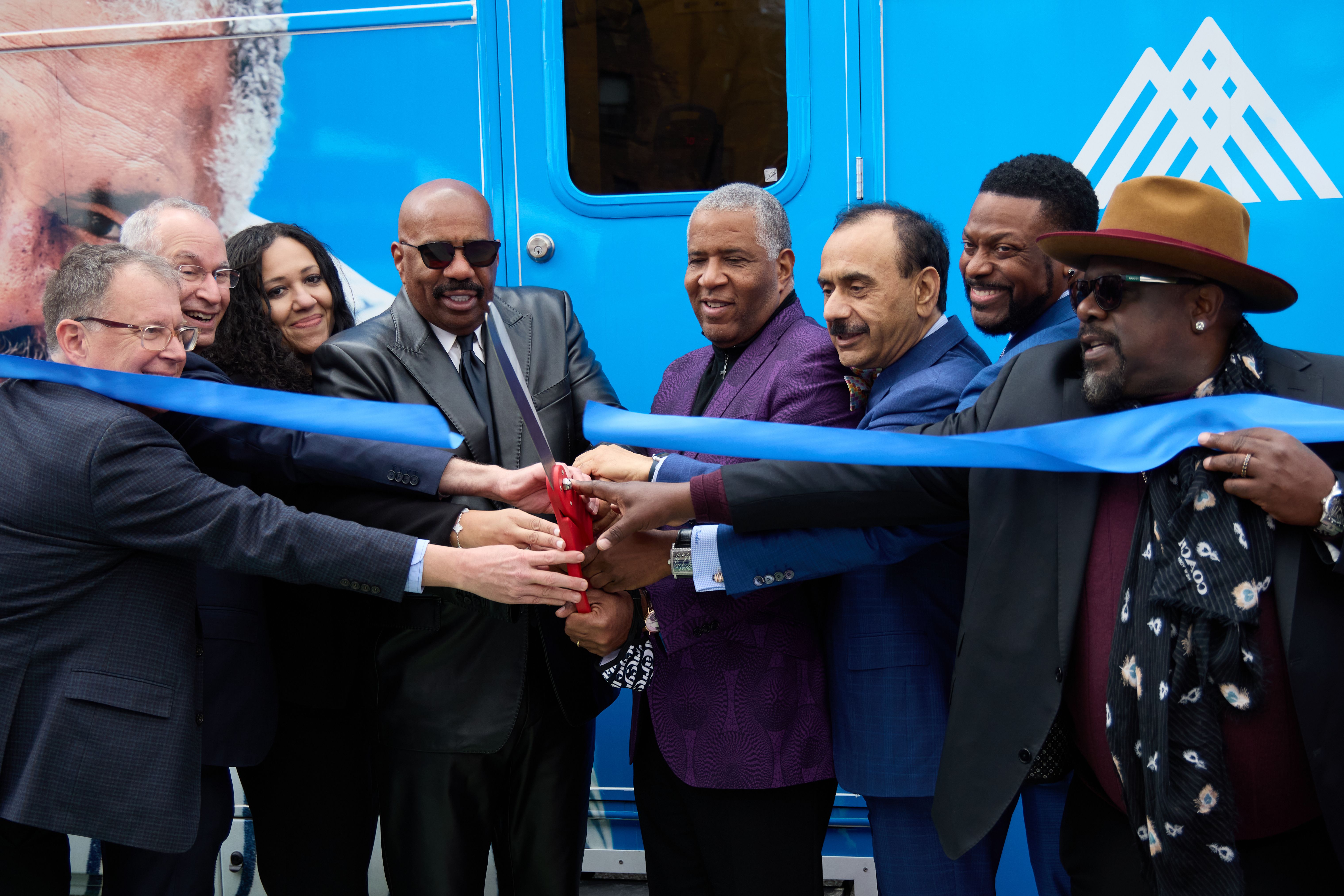 Robert F. Smith (center) joins Steve Harvey, Chris Tucker and Cedric the Entertainer and members of Mount Sinai Health System to cut the ribbon of the mobile prostate cancer screening unit.