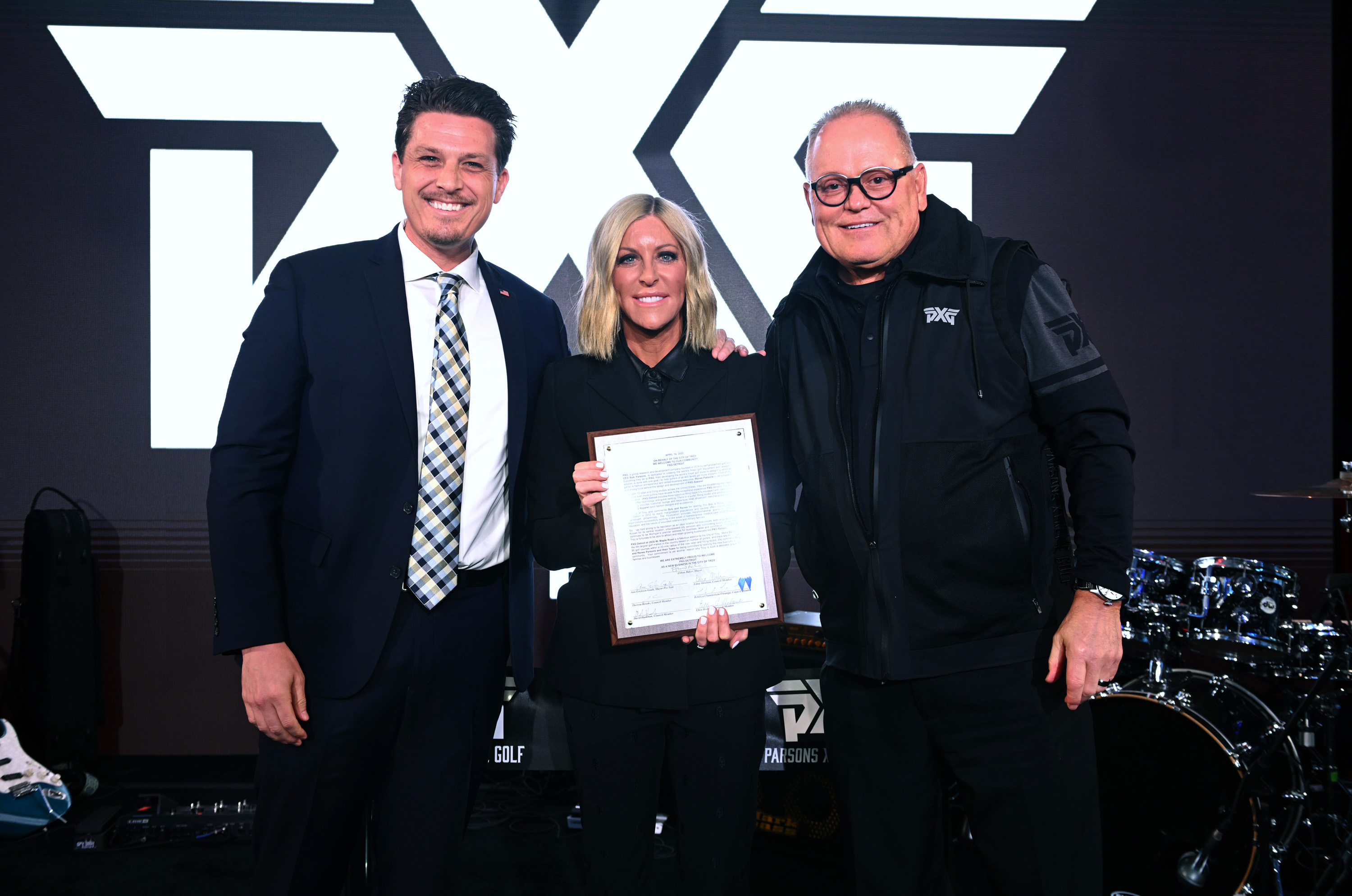 Mayor of Troy Ethan Baker, Renee Parsons and Bob Parsons appear onstage at the PXG Detroit Grand Opening Celebration on April 14, 2022.