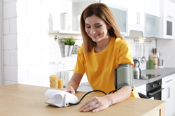 Woman taking blood pressure at home