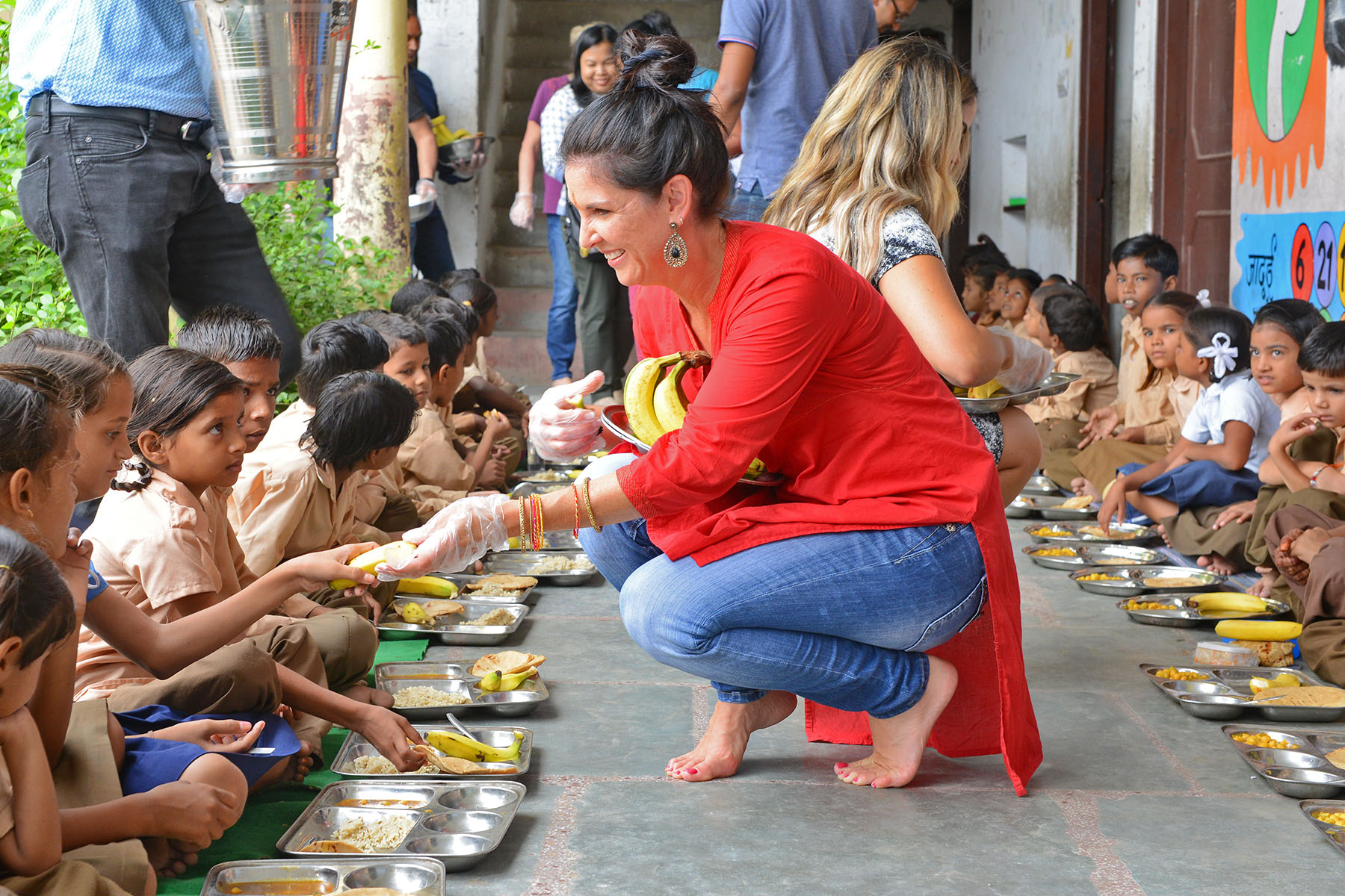 Shop LC employees help serve meals to schoolchildren in India.