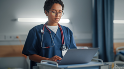 A triage nurse reviews secure patient data on her laptop as part of SOC 2 certification.