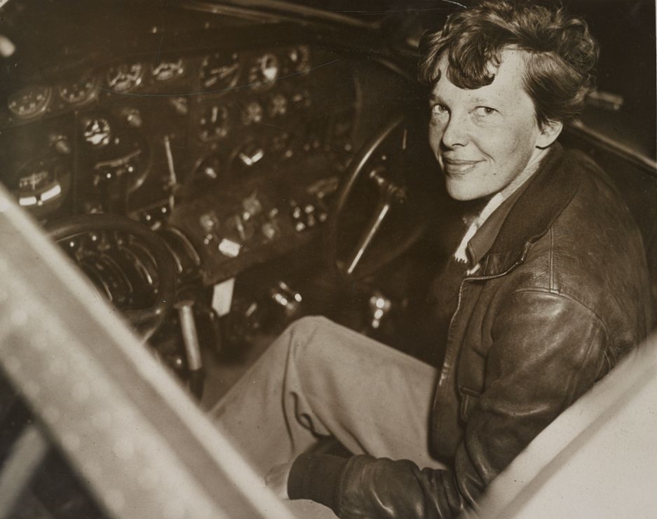 Amelia Earhart wearing leather flying jacket in cockpit of Lockheed Electra 10-E, 1937