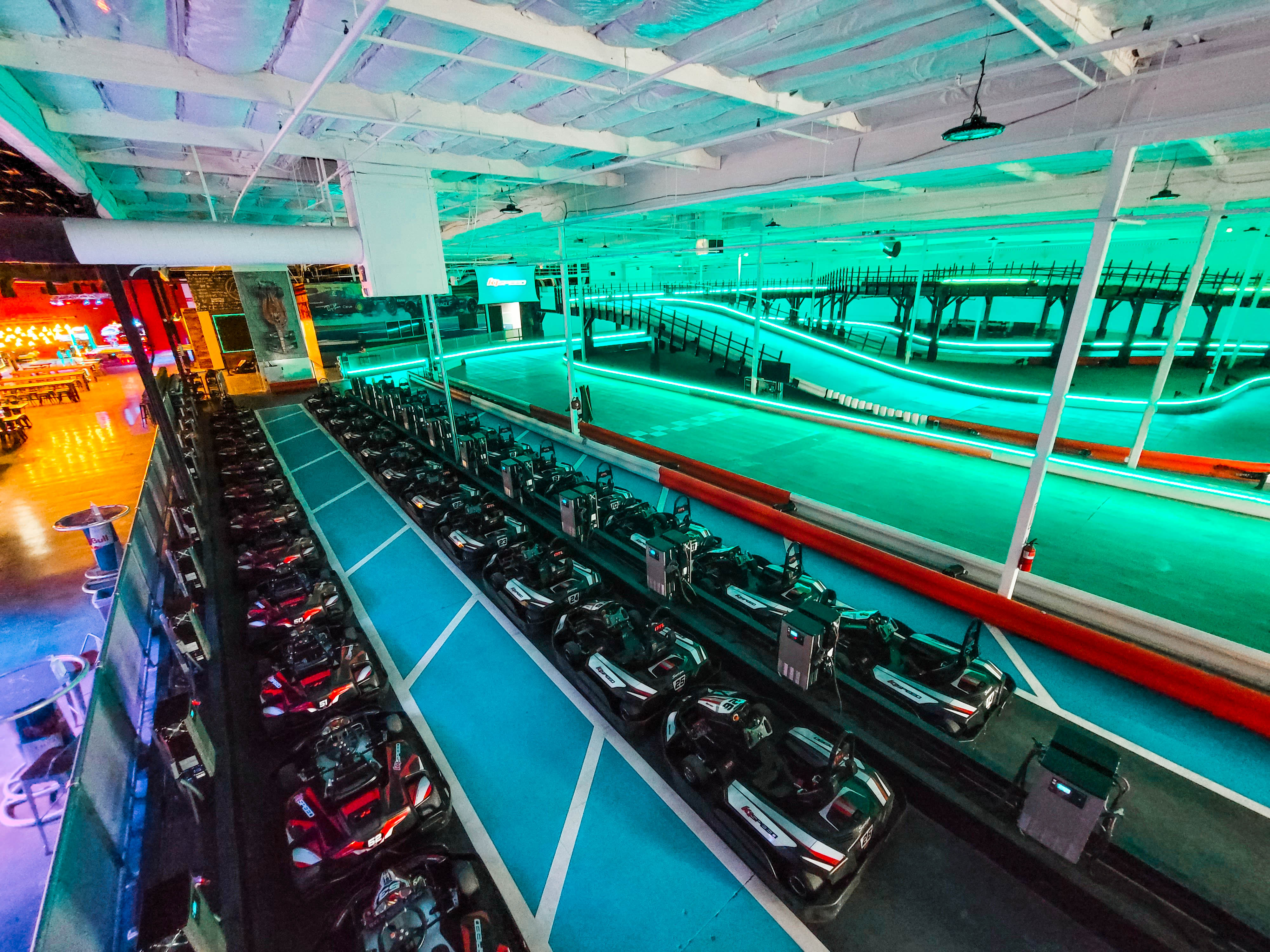 The indoor kart track is lined with LED lighting