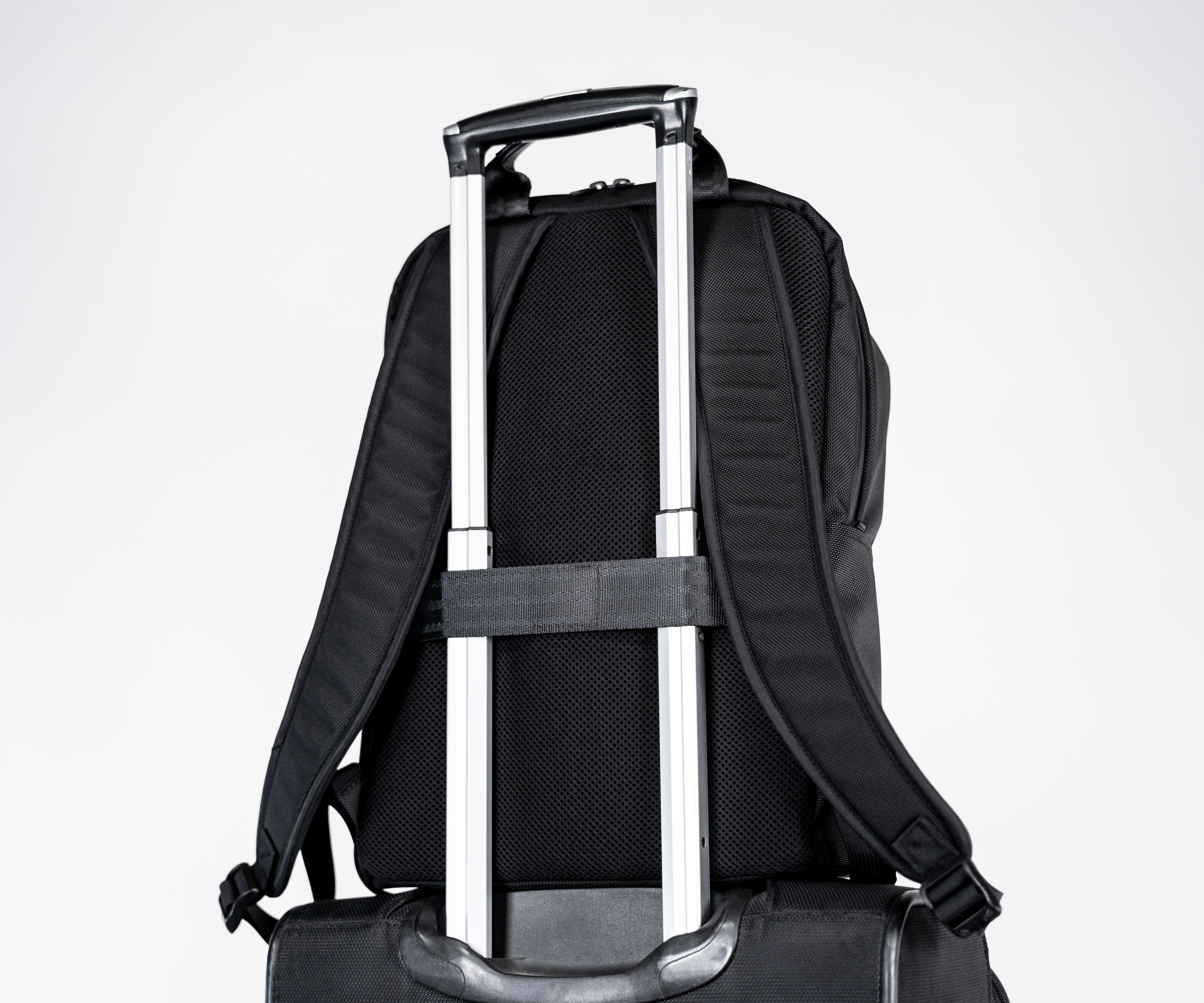 Wheeled suitcase passthrough and moisture-wicking mesh padding