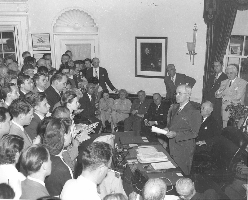 President Harry S. Truman (standing at desk) announces surrender of Japan to reporters, August 14, 1945; photo courtesy Harry S. Truman Presidential Library