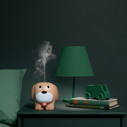 Sprout the Puppy Diffuser on a nightstand with a lamp and books