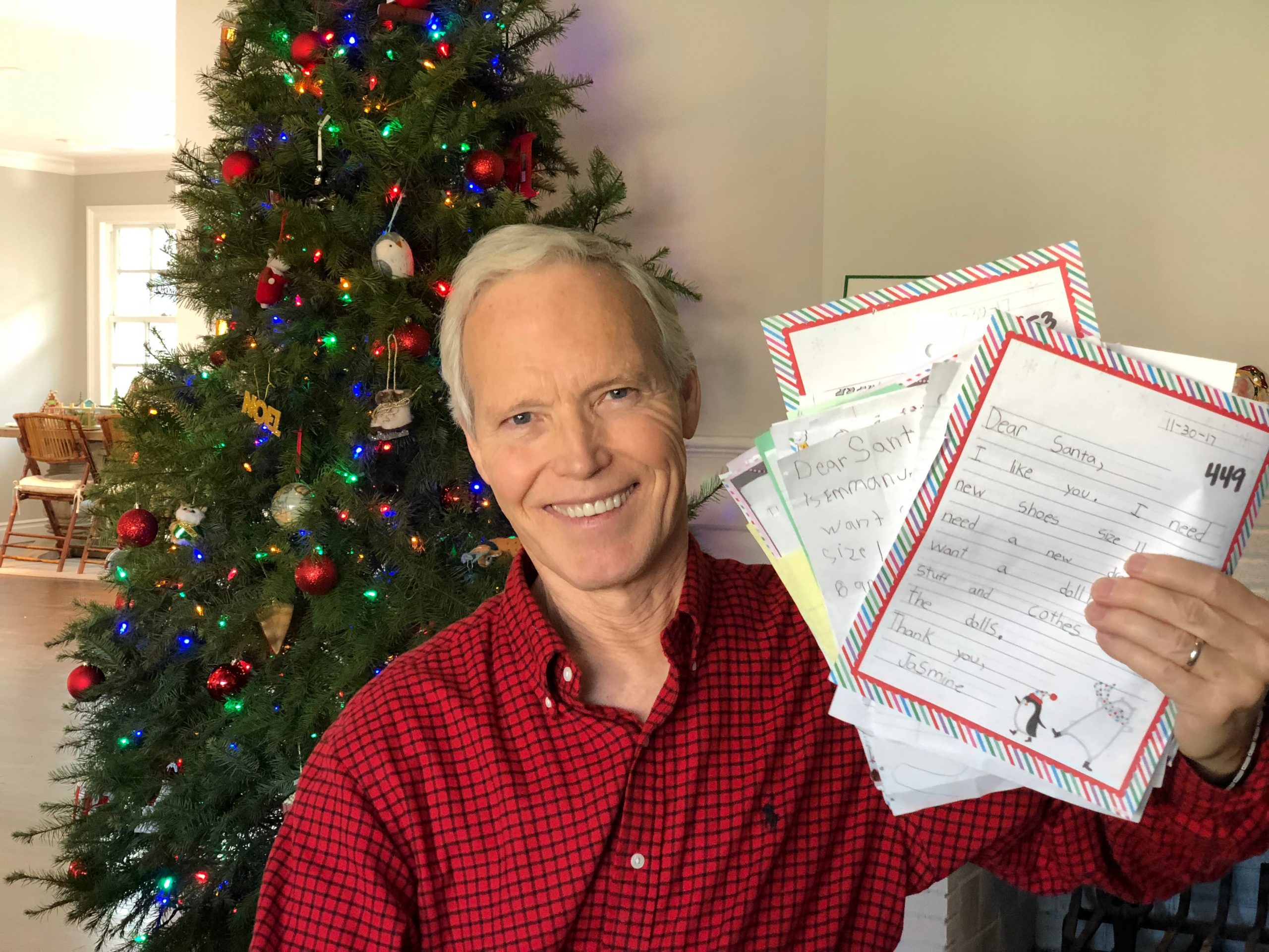 Patrick Reynolds, Chief Elf at BeAnElf.org, holds up letters to Santa adopted by the Christmas charity he runs.