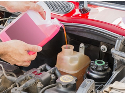 technician changing coolant in a car
