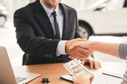 Woman shaking hand after buying a new vehicle