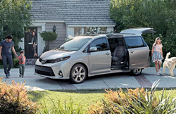 A family of four with a dog around the Toyota Sienna