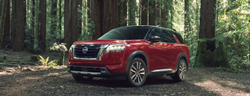 2023 Nissan Pathfinder Red parked in the forest area