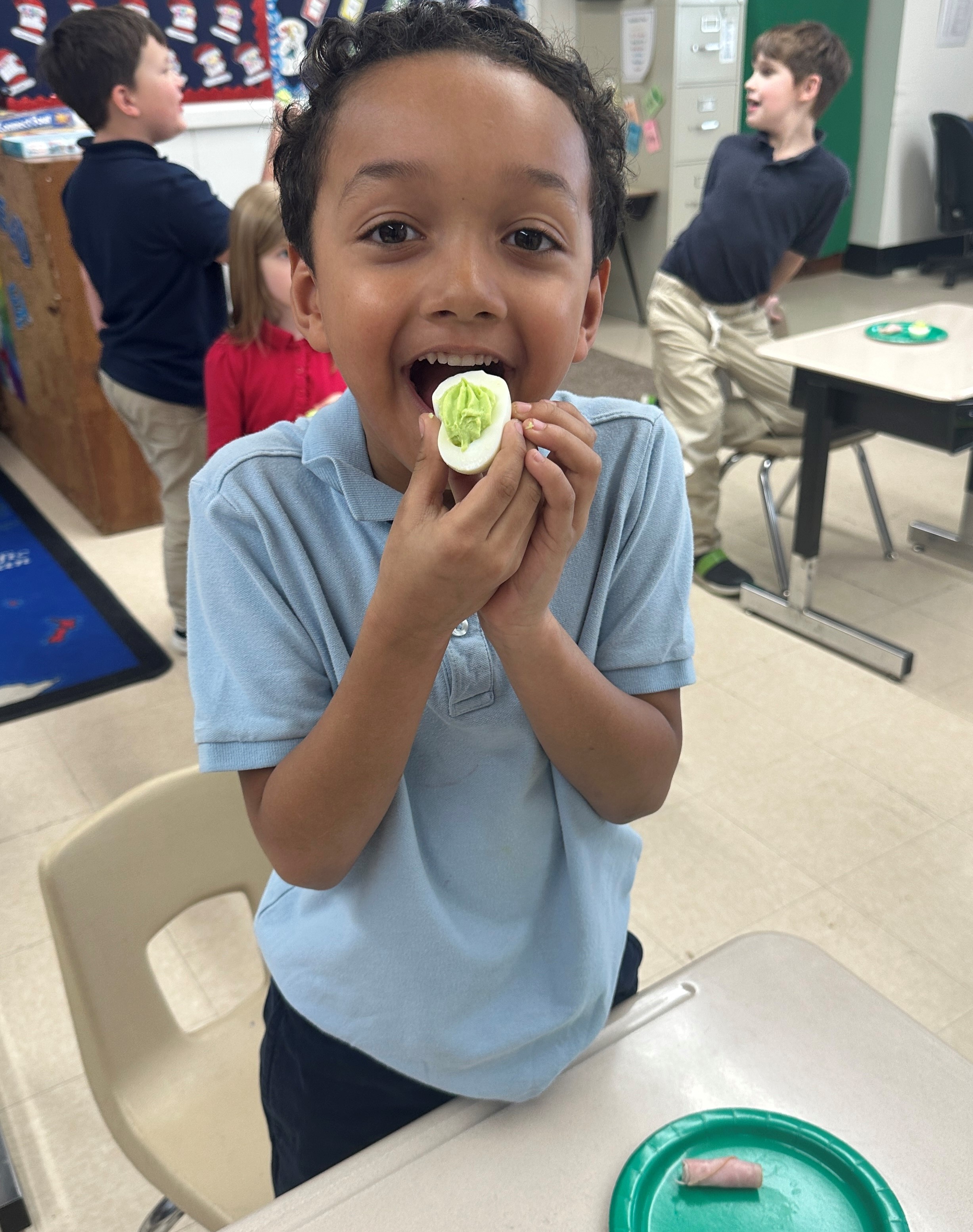 A student tries "green eggs" as part of their Read Across America lesson.