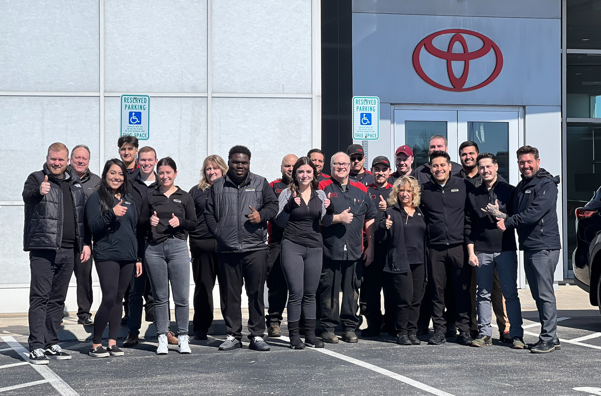 Team members pose for a picture in front of the award-winning Toyota dealer in Racine