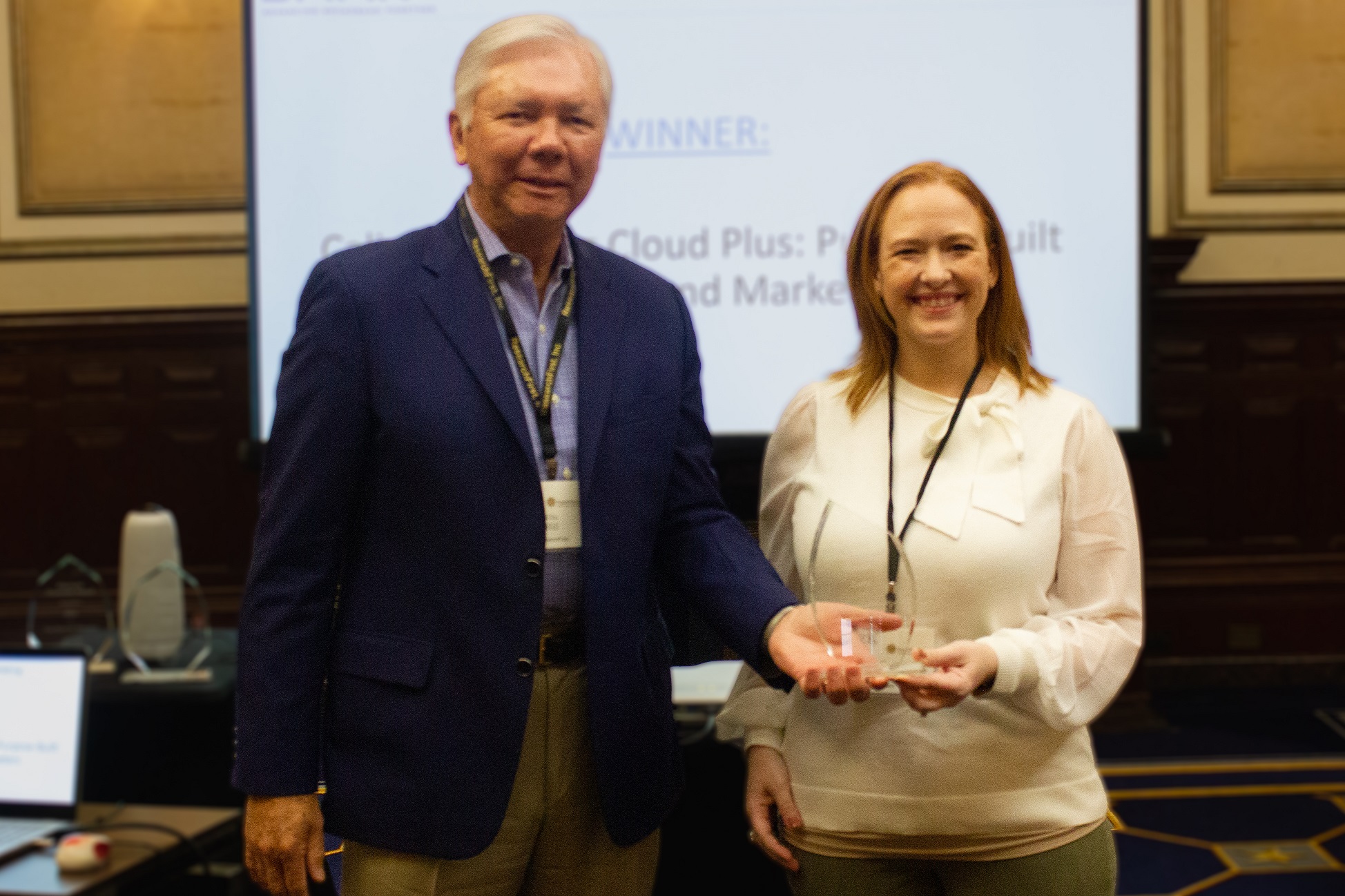 Chelsi Runyan, Senior Business Insights Services Manager at Calix (right) accepts the Vendor Marketing Award from Ellis Hill, President of ResearchFirst (left).