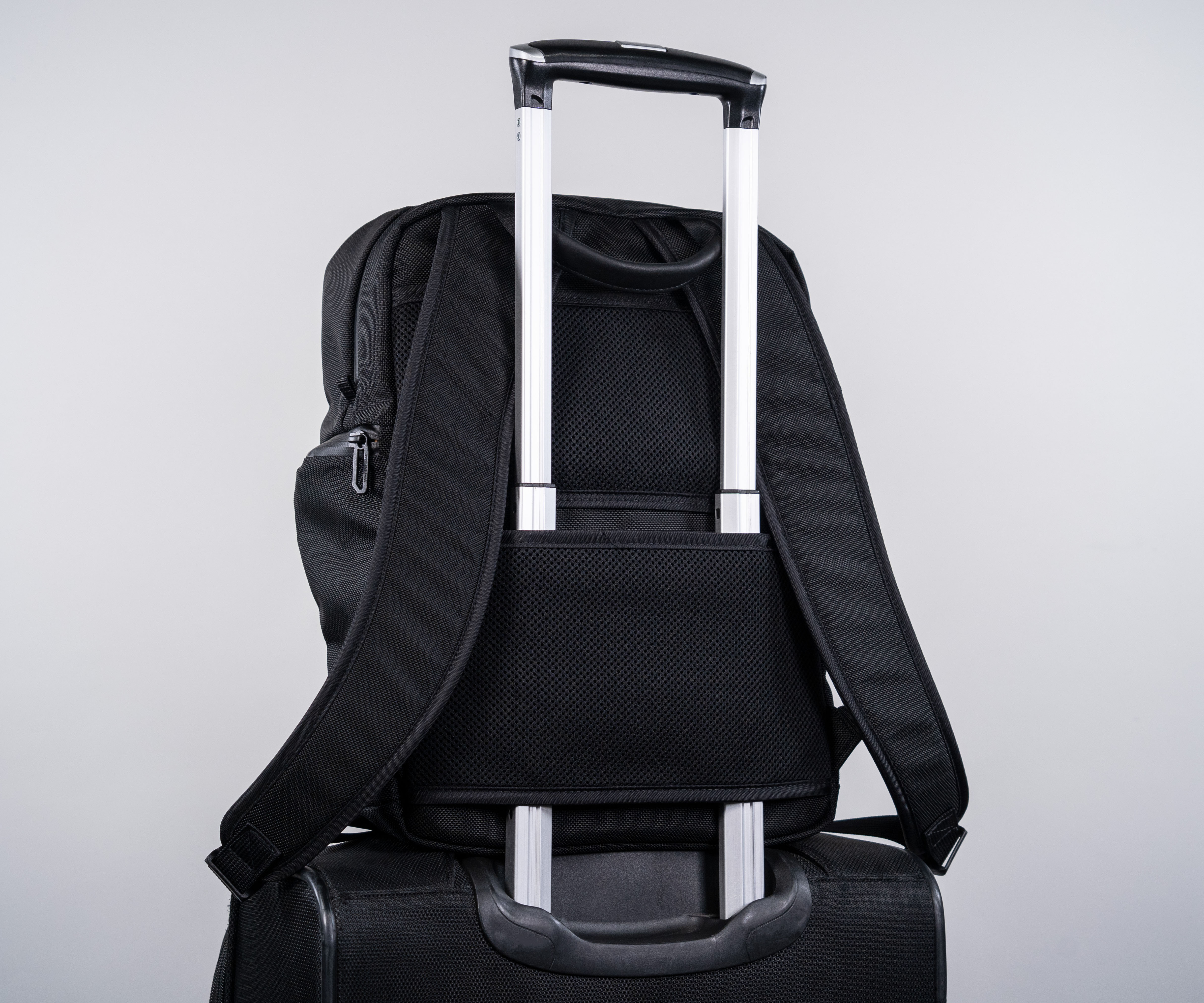 Padded mesh panel doubles as suitcases handle pass-through.