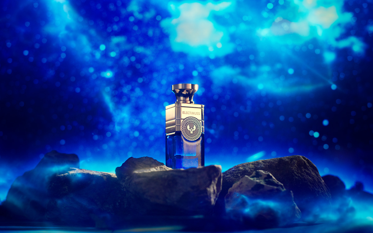 Aquila Absolute perfume standing on moon rocks with the night sky behind