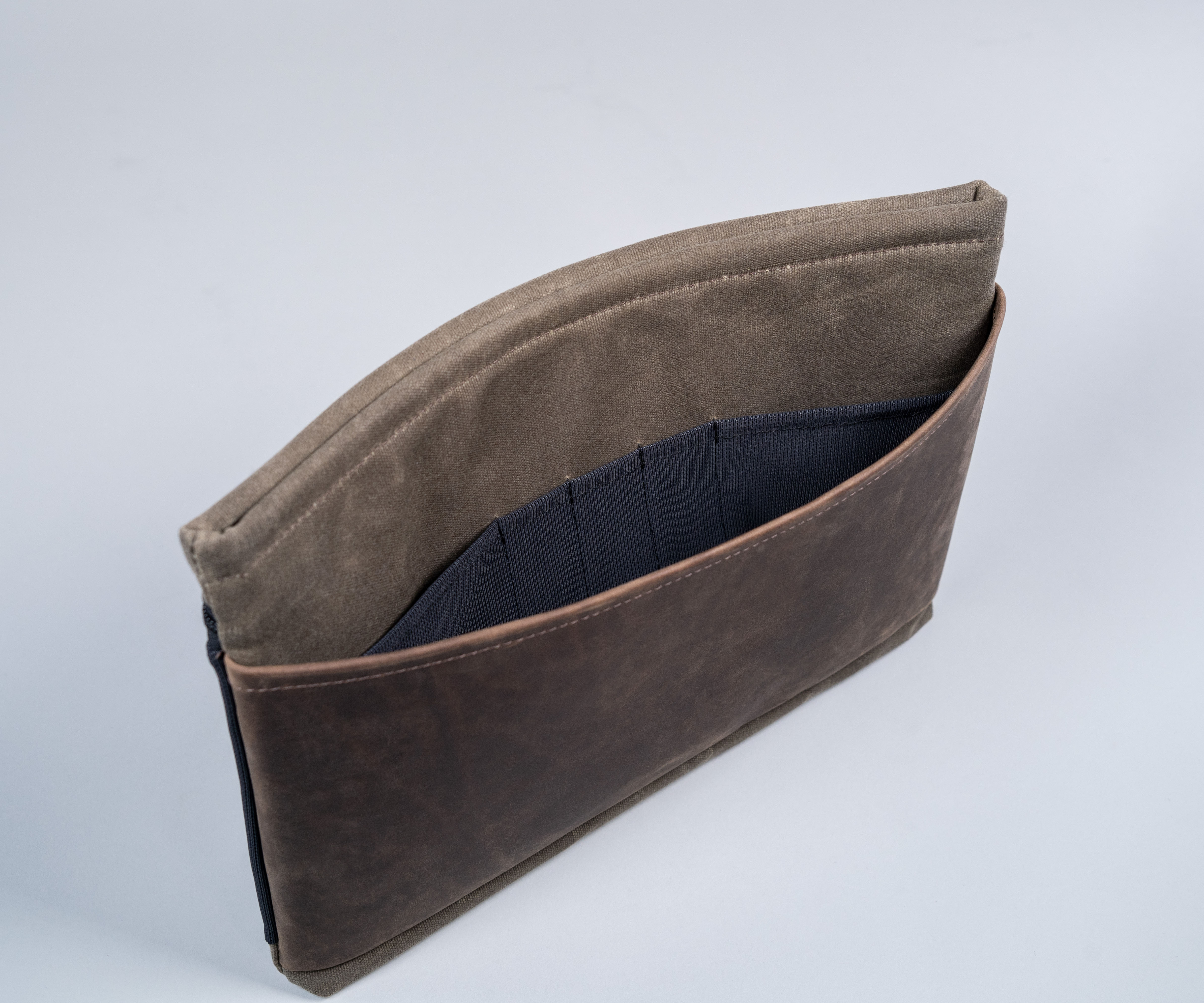 Front leather panel includes internal mesh organization pockets