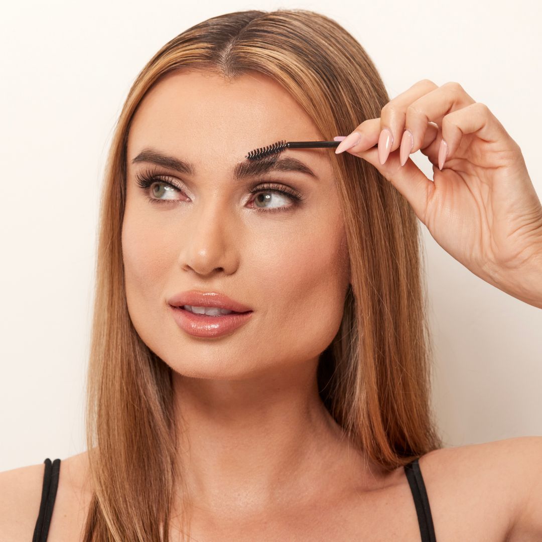 Model brushing Madluvv Clean Girl Brow Slick™ to create perfectly groomed brows.