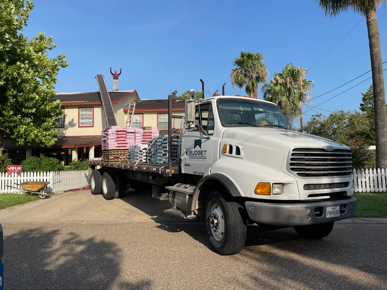 Budget Roofing Supply delivery truck delivering residential shingles and accessories to a residential roofing jobsite.